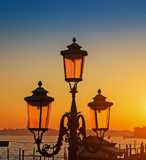 Farola junto al mar al atardecer en Venecia Italia