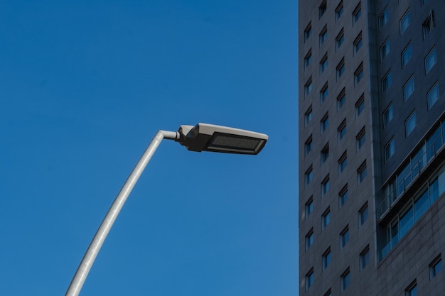 Farola en primer plano y fachada de un edificio moderno Perspectiva engañosa