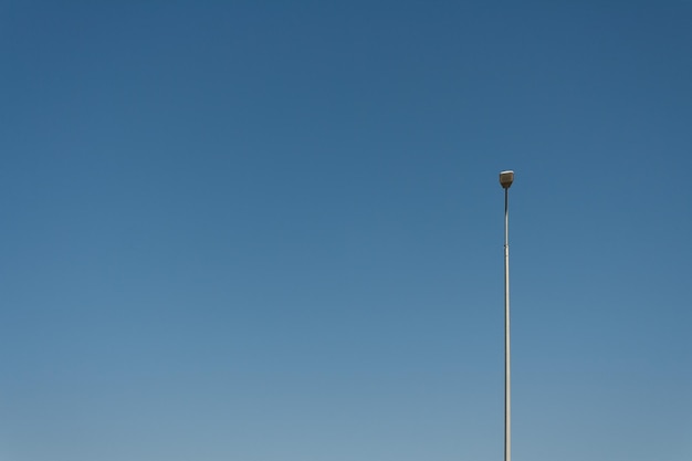 Una farola solitaria contra el cielo azul un lugar para copiar