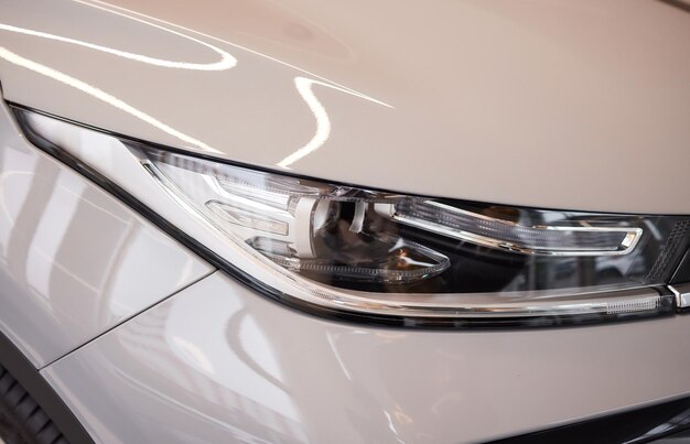 Faros y capó de coche deportivo blanco con estrellas plateadas.