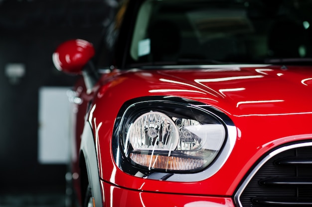 Faros y capó del coche rojo deportivo en garaje