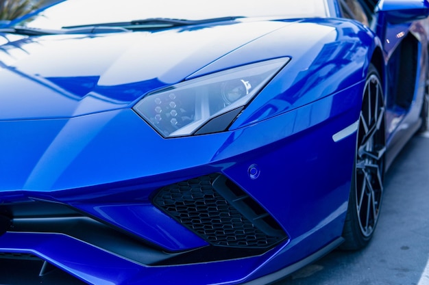 Foto faros delanteros de un automóvil deportivo moderno azul en el fondo de la playa de la ciudad