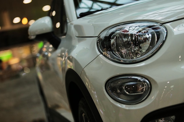 Faros delanteros de coche blanco de un nuevo coche blanco sobre un fondo bokeh