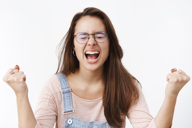 Farto de uma jovem colega de trabalho pressionada em óculos deixando escapar raiva e raiva gritando em voz alta com os olhos fechados enquanto levantando as mãos e cerrando os punhos perdendo a paciência por irritação e aborrecimento