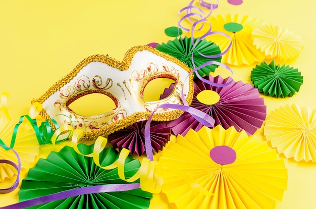 Foto fãs de carnaval colorido e máscara na mesa amarela