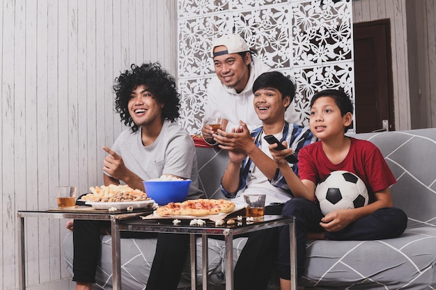 fãs de esportes assistindo jogo de futebol na televisão juntos na sala crianças controlam o controle remoto