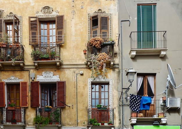 Fasadas autênticas antiquadas com janelas e varandas desgastadas em Cagliari Sardenha Itália Arquitetura italiana antiga vintage