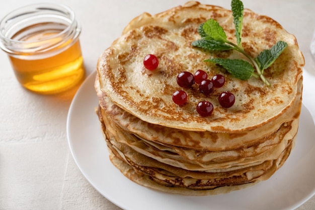 Faschingspfannkuchen werden auf der Holzplatte gestapelt Dünne Pfannkuchen mit knuspriger Kruste Pfannkuchen