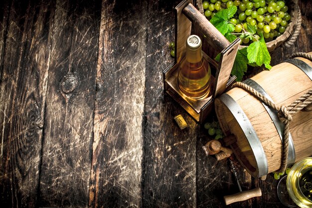 Fass Weißwein mit Zweigen grüner Trauben.