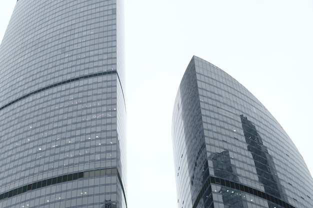 Fassade des modernen Wolkenkratzers mit Glaswänden Von unten des zeitgenössischen hohen Wolkenkratzers mit Glaswänden gegen bewölkten Himmel in der Innenstadt