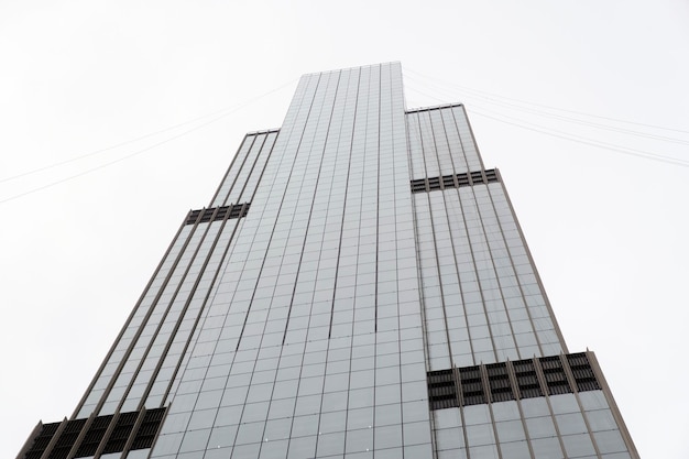 Fassade des modernen Wolkenkratzers mit Glaswänden Von unten des zeitgenössischen hohen Wolkenkratzers mit Glaswänden gegen bewölkten Himmel in der Innenstadt