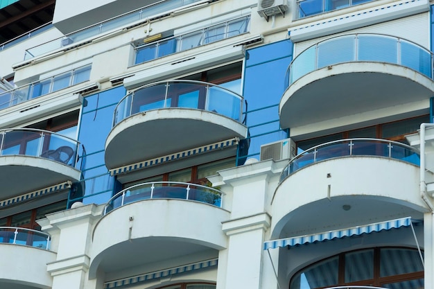 Fassade eines modernen Gebäudes mit Balkonen und blauem Glas in einem europäischen Resort Nahaufnahme