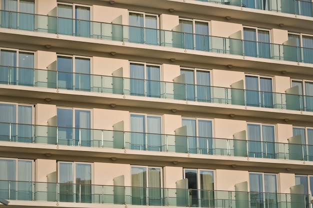 Fassade eines modernen großen Hotels mit Fenstern und offenen Balkonen im Sonnenschein und Tageslicht