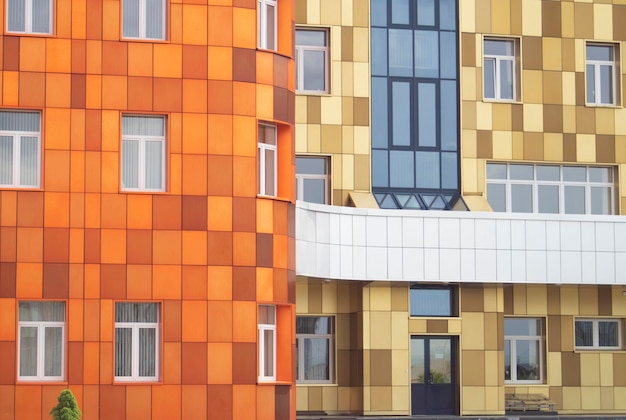 Fassade eines modernen mehrstöckigen Gebäudes, das mit farbigen Fliesen gesäumt ist
