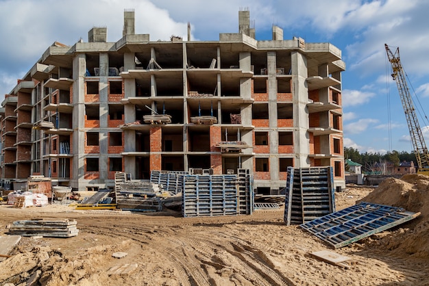 Fassaden eines mehrstöckigen Gebäudes im Bau Baustellenwerkzeuge Schubkarre Sand a