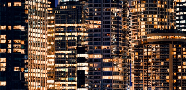 Fassadenfenster des beleuchteten modernen Wolkenkratzers mit Bürogebäude bei Nacht