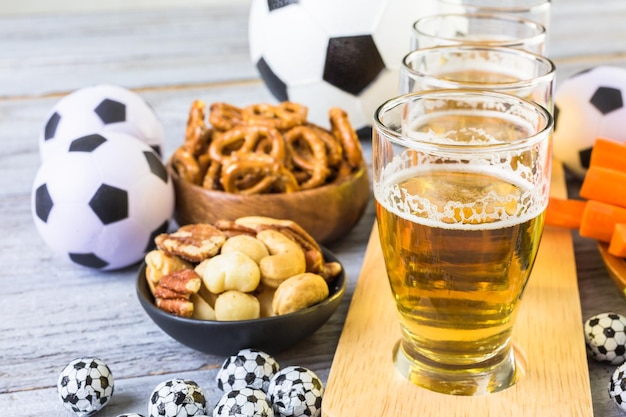 Fassbier und salzige Snacks auf dem Tisch für die Fußballparty.