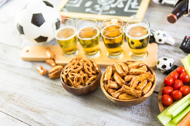 Fassbier und salzige Snacks auf dem Tisch für die Fußballparty.