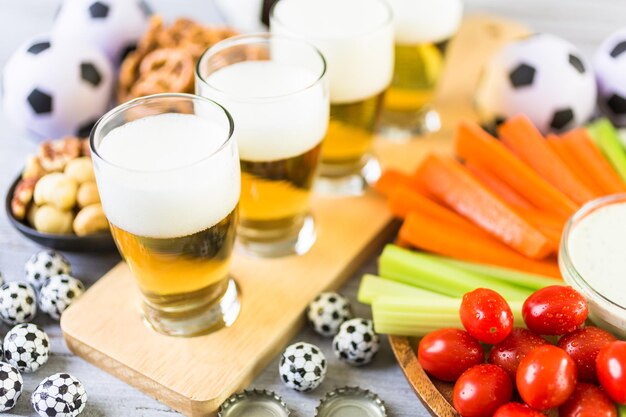 Foto fassbier und salzige snacks auf dem tisch für die fußballparty.