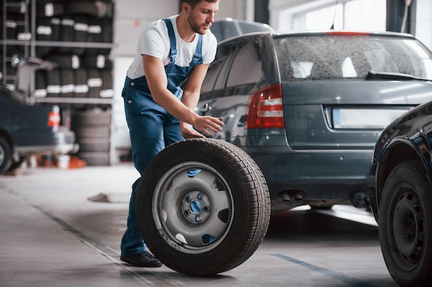 Fast dort. Mitarbeiter in der blau gefärbten Uniform arbeitet im Autosalon