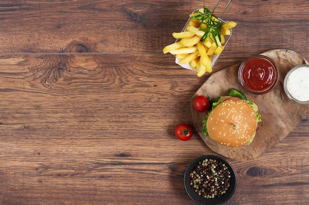 Fast-Food-Burger-Menü Pommes frites und Ketchup-Sauce auf Draufsicht des hölzernen Hintergrundes