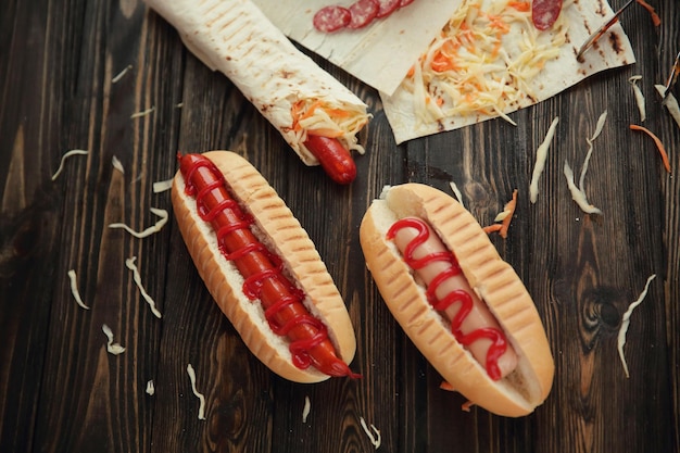 Fast Food Hot Dogs mit Soße auf Holzhintergrund