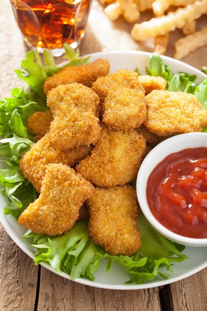 Fast-Food-Hühnernuggets mit Ketchup, Pommes Frites, Cola