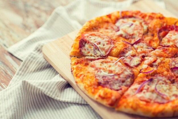 Fast Food, italienische Küche und Esskonzept - Nahaufnahme von hausgemachter Pizza auf Holztisch