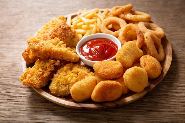 Foto fast-food-mahlzeiten zwiebelringe pommes frites chicken nuggets und brathähnchen