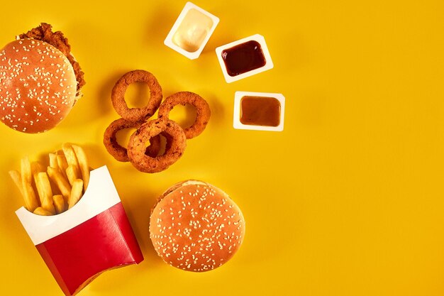Fast-Food- und ungesundes Ernährungskonzept Nahaufnahme von Fast-Food-Snacks auf gelbem Hintergrund