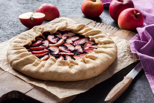 Fastenzeit süße Galette mit Äpfeln und Holunderbeeren auf Holzbrett