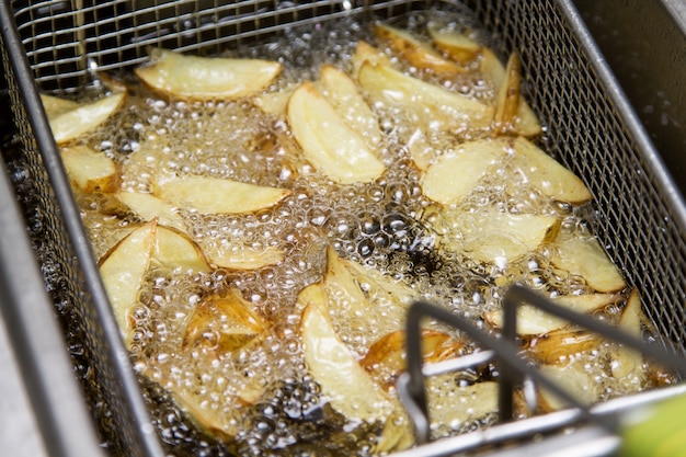 Fastfoodküche - Kartoffeln, die im Öl braten