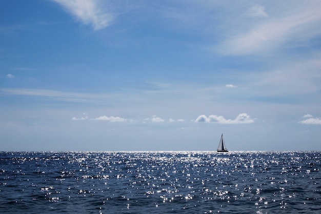 Faszinierender blick auf die meereslandschaft mit einem segelboot mit sonnigem himmel