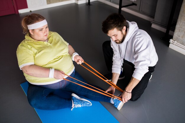 Fat Woman Stretching in der Fitnessklasse