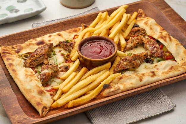 Fatayer Chicken Kebab mit Pommes und Ketchup serviert in einem Gericht isoliert auf grauem Hintergrund Seitenansicht von Fastfood