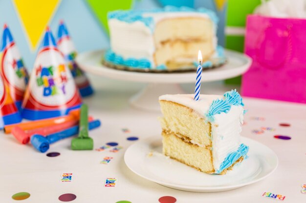 Fatia de bolo de aniversário branco simples com glacê branco e azul.