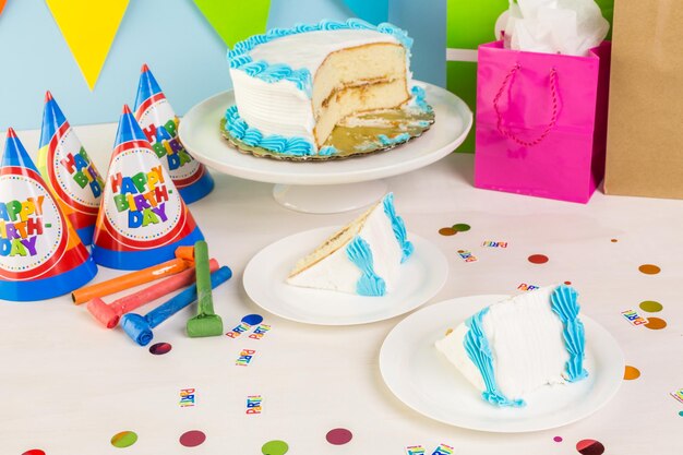 Foto fatia de bolo de aniversário branco simples com glacê branco e azul.