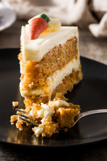 Fatia de bolo de cenoura doce em um prato na mesa de madeira