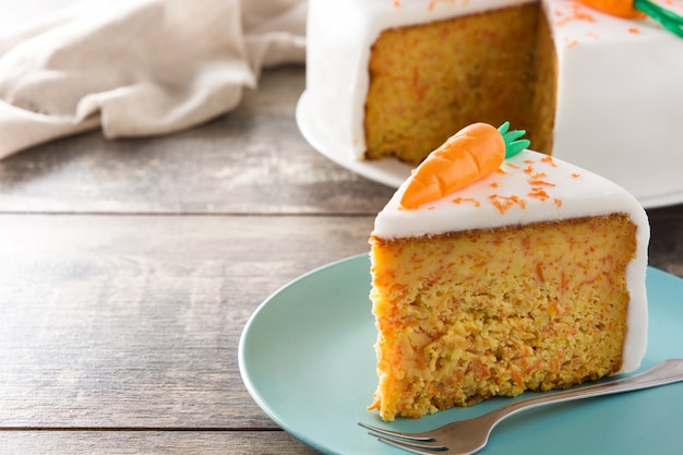 Fatia de bolo de cenoura doce na mesa de madeira