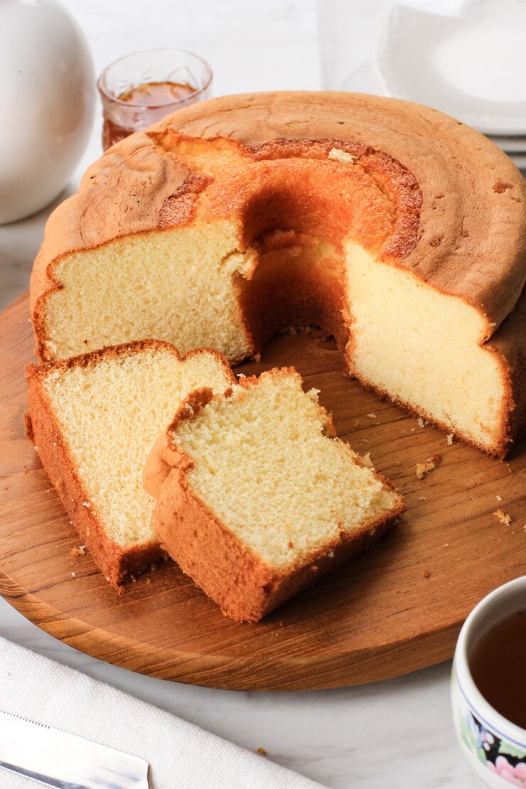 Foto fatia de bolo de chiffon de baunilha fofo ou bolo de esponja em prato de pedra preta, servido com chá e mel. conceito de fotografia de alimentos brilhantes para padaria