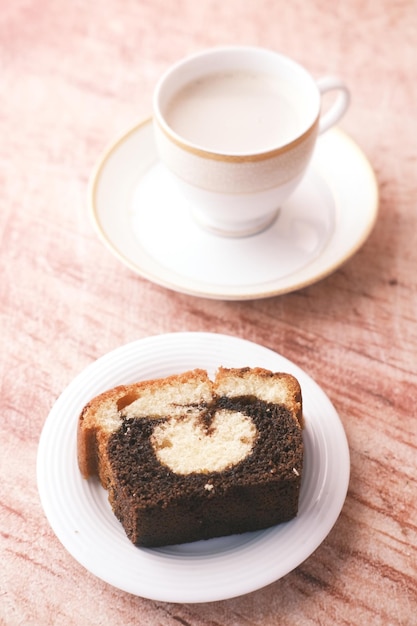 Fatia de bolo de chocolate de confeitaria e chá na mesa