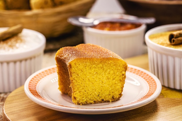 Fatia de bolo de fubá tradicional bolo de milho caseiro do Brasil em festas juninas com doces rústicos ao fundo