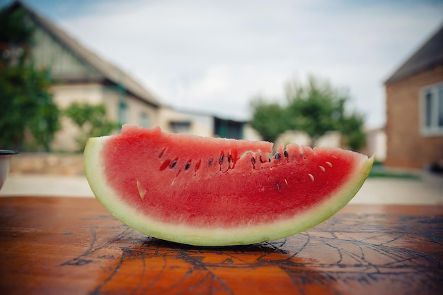 Fatia de close-up de melancia vermelha madura em um fundo desfocado. Baga deliciosa para crianças e adultos