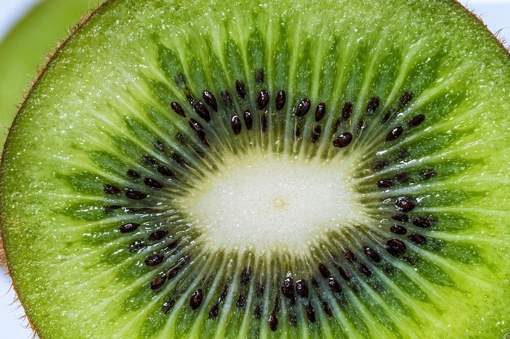 Foto fatia de fruta de kiwi com macro textura de kiwi em uma moldura completa