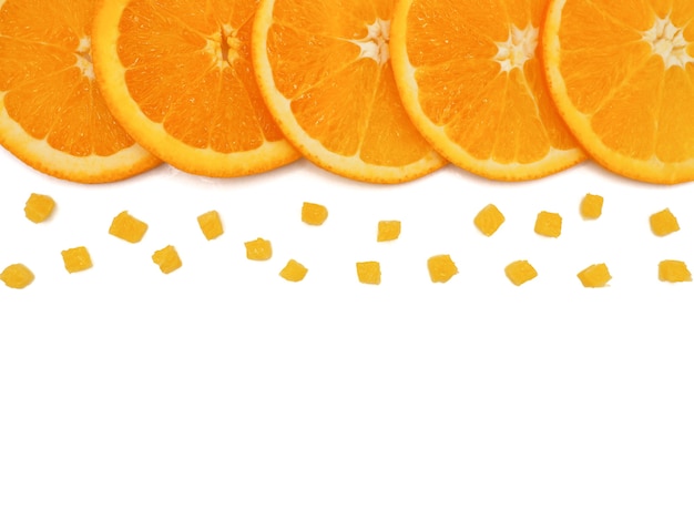 Fatia de laranja fresca e pequenos pedaços no fundo branco