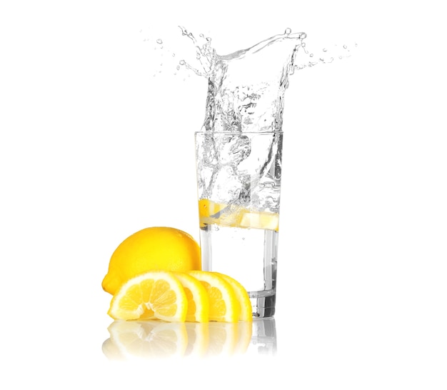 Fatia de limão fresco caindo em um copo com água no fundo branco