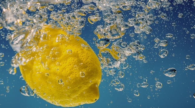 Fatia de limão subaquática em água com gás ou limonada com bolhas Coquetel efervescente tônico refrigerante refrescante Close-up de limões e cubos de gelo em vidro Limão em salpicos de água com gás bebida gelada