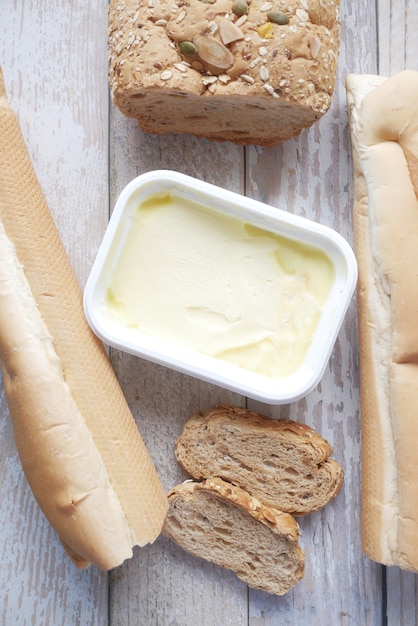 Fatia de manteiga e pão integral na tábua de cortar