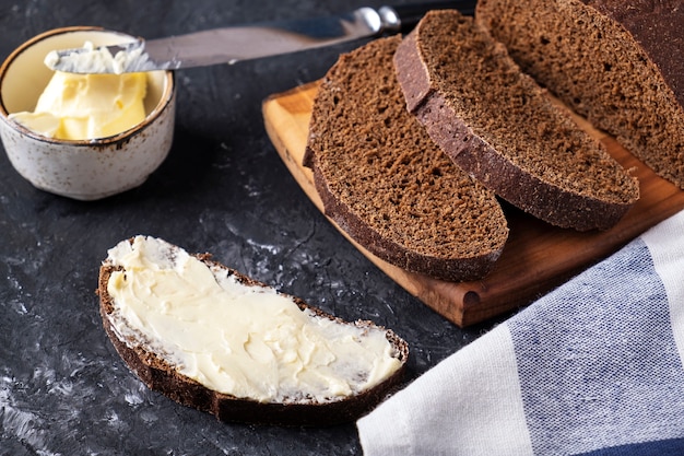 Fatia de pão escuro com manteiga.