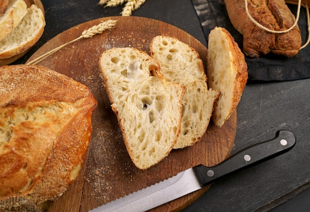 Fatia de pão fresco e faca de corte na mesa rústica Conceito de produtos agrícolas naturais de pão caseiro